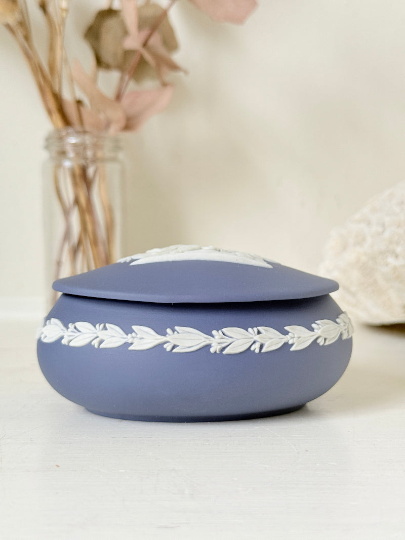Vintage Wedgwood Jasperware Portland blue round lidded trinket box, decorated with a white neoclassical cameo and laurel wreath border.