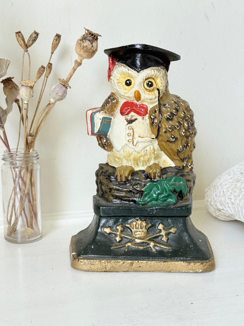 vintage hand painted cast iron owl doorstop with mortarboard and bow tie on white surface