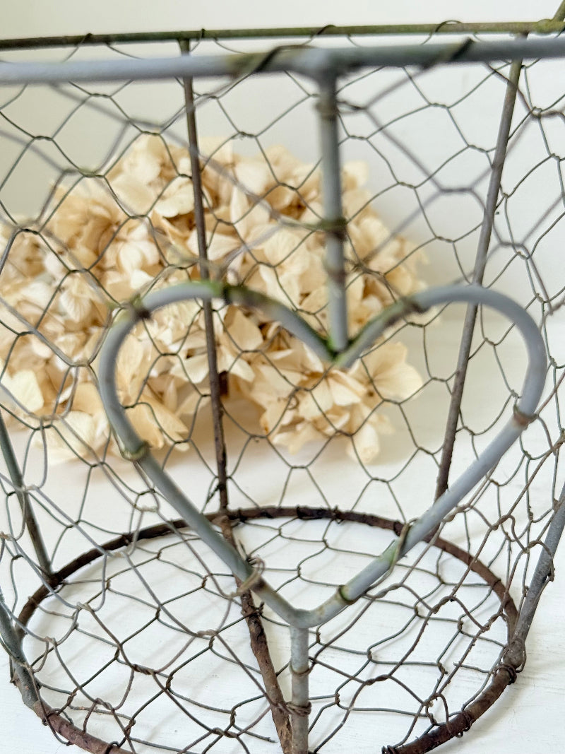 Pair of vintage decorative wire baskets with heart detail and aged patina photographed on a white surface