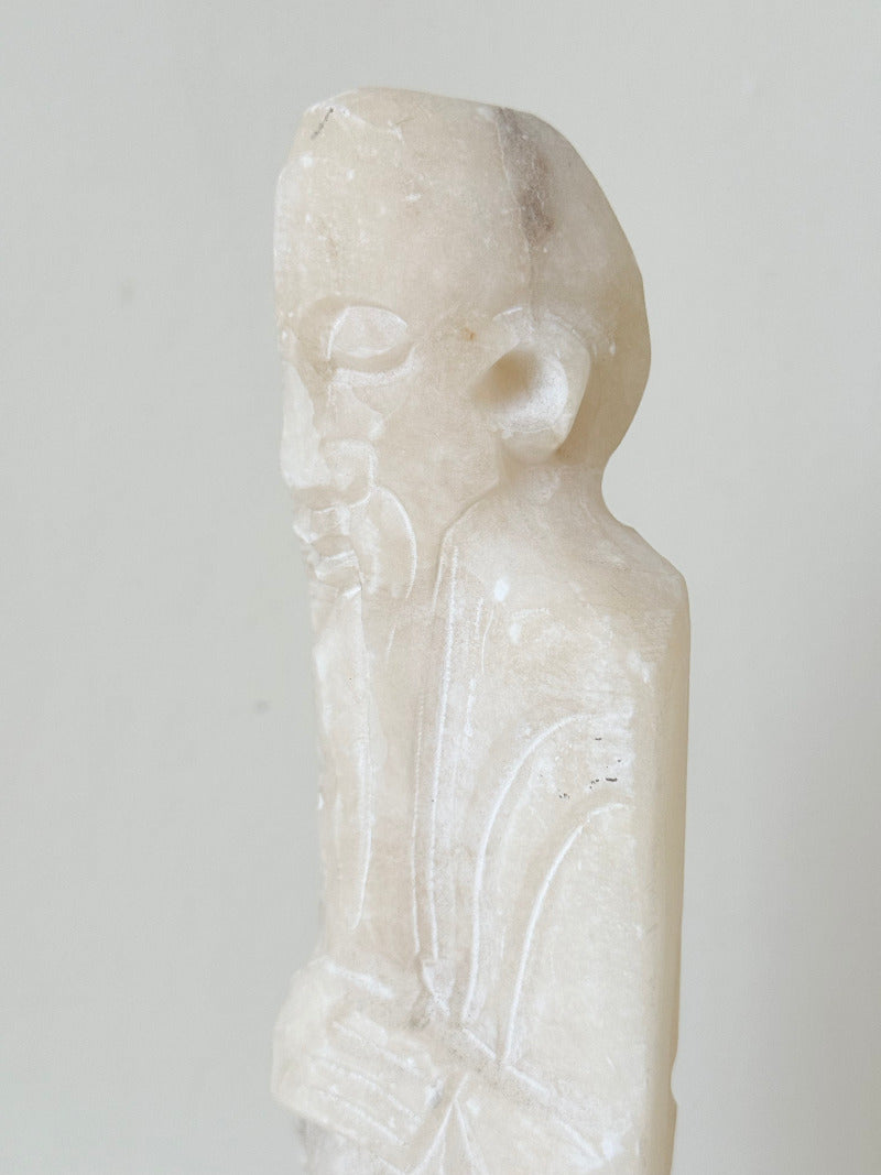 vintage alabaster gentleman figure on square base with carved detail, photographed on white surface with hydrangea flowers.