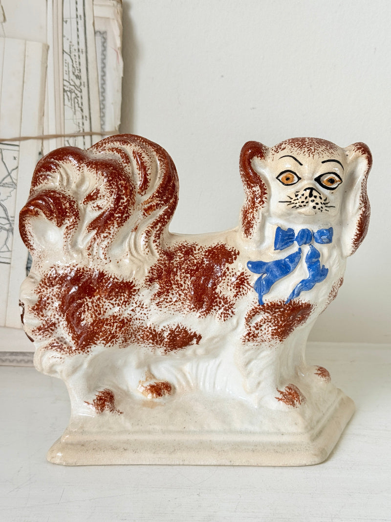 Pair of antique standing Staffordshire Pekingese dogs in rust red and white with blue painted bows