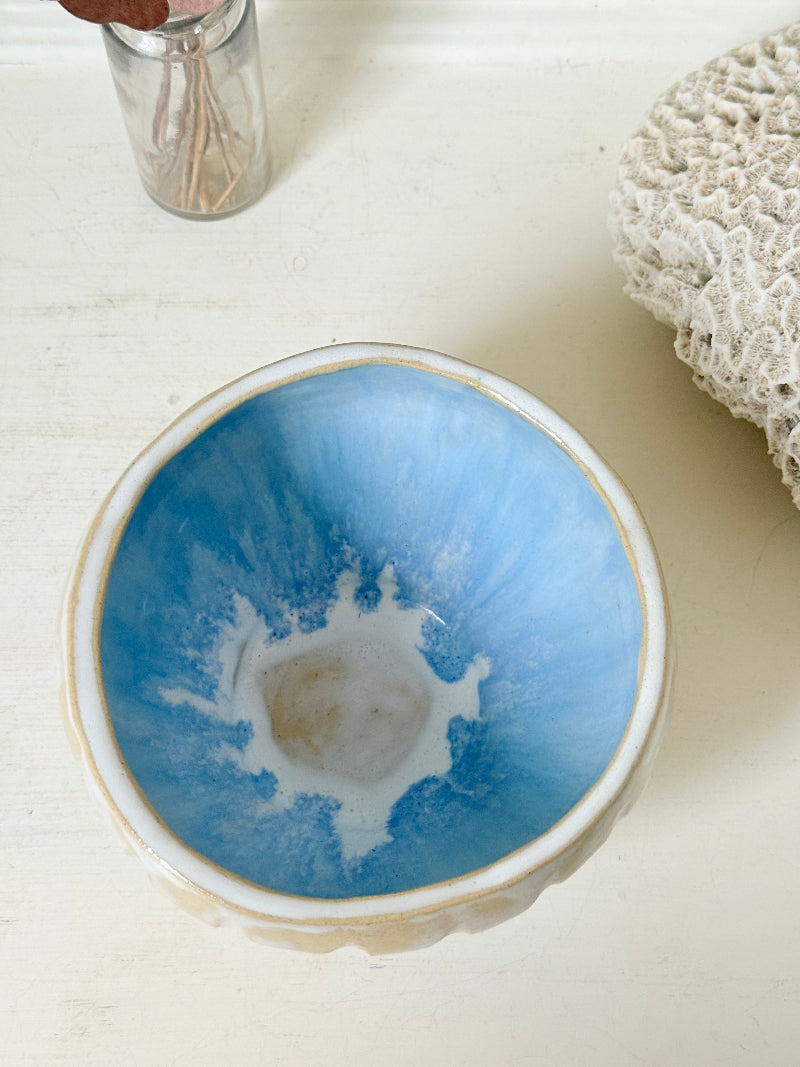 Vintage studio pottery bowl planter in cream and sky blue glaze photographed on a white surface