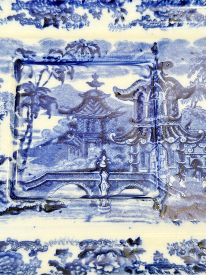 Vintage Wedgwood blue and white rectangular transferware plate with scenic design photographed on a white surface