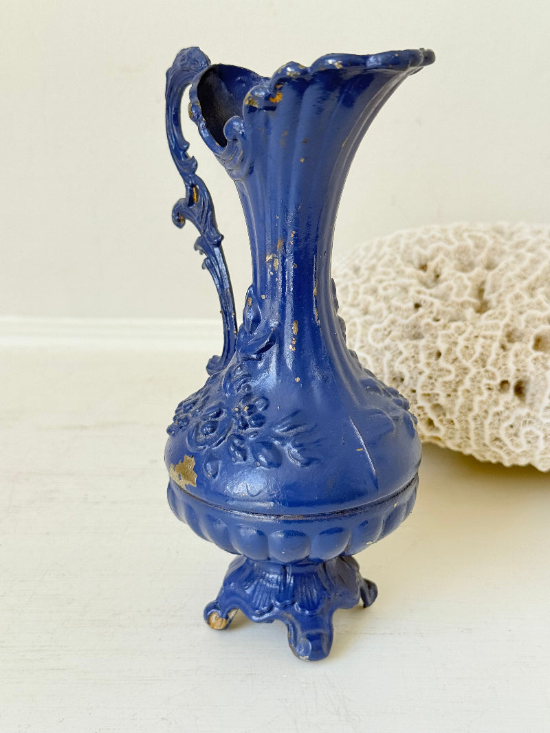 Blue vintage metal jug with ornate Rococo handle and relief decoration, shown on white background
