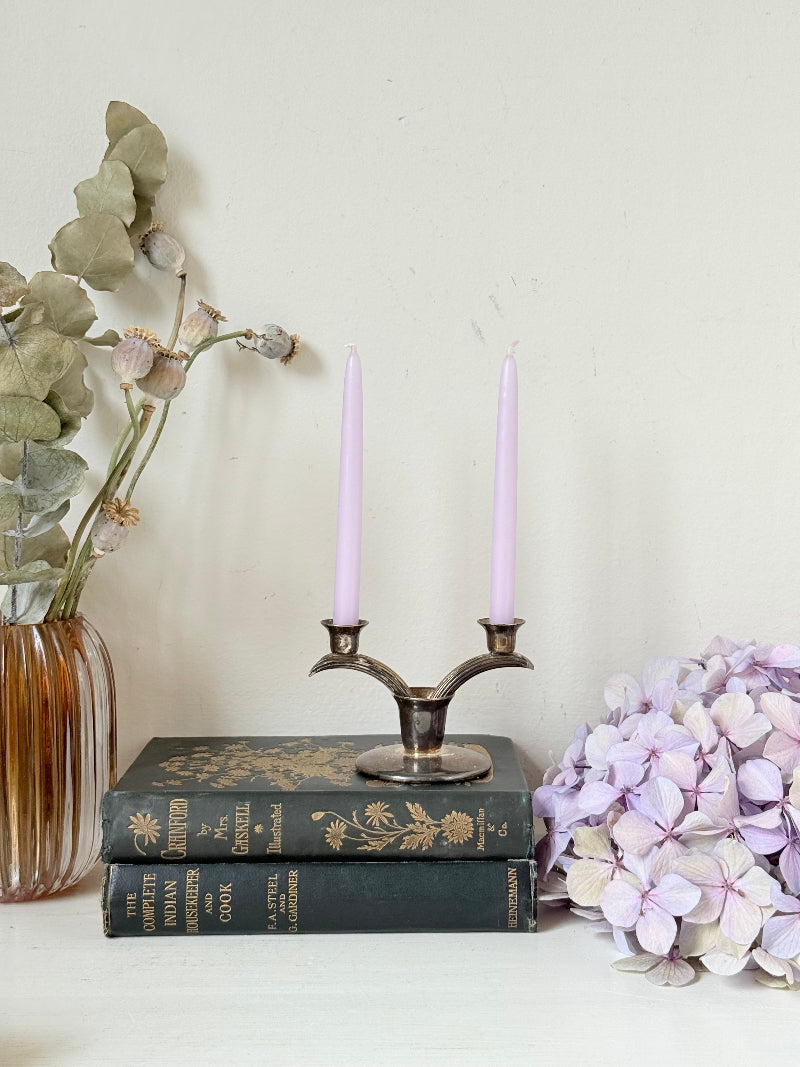 Vintage miniature silver plate candlestick with twin holders, photographed on white surface