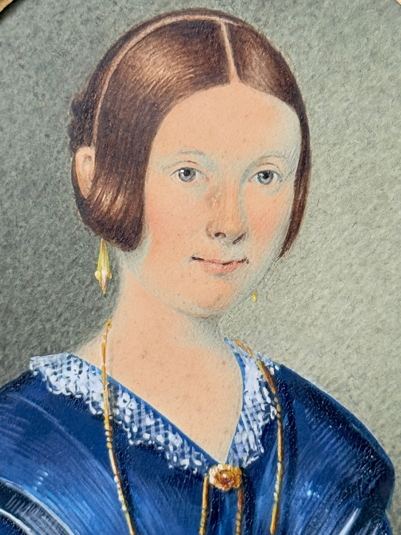19th century watercolour miniature portrait of woman in blue dress, oval ebonised frame, styled on white background