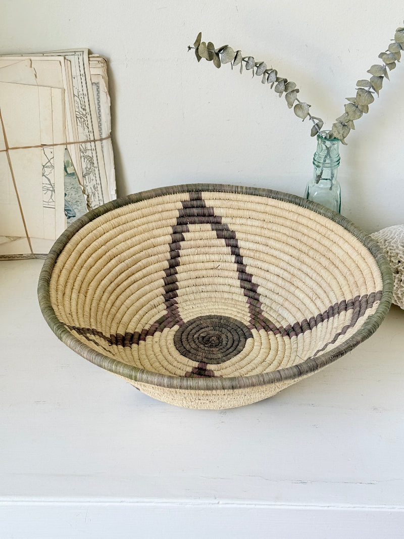 Large hand woven coiled basket with three point star pattern, natural fibre and dark geometric detail for wall or table styling