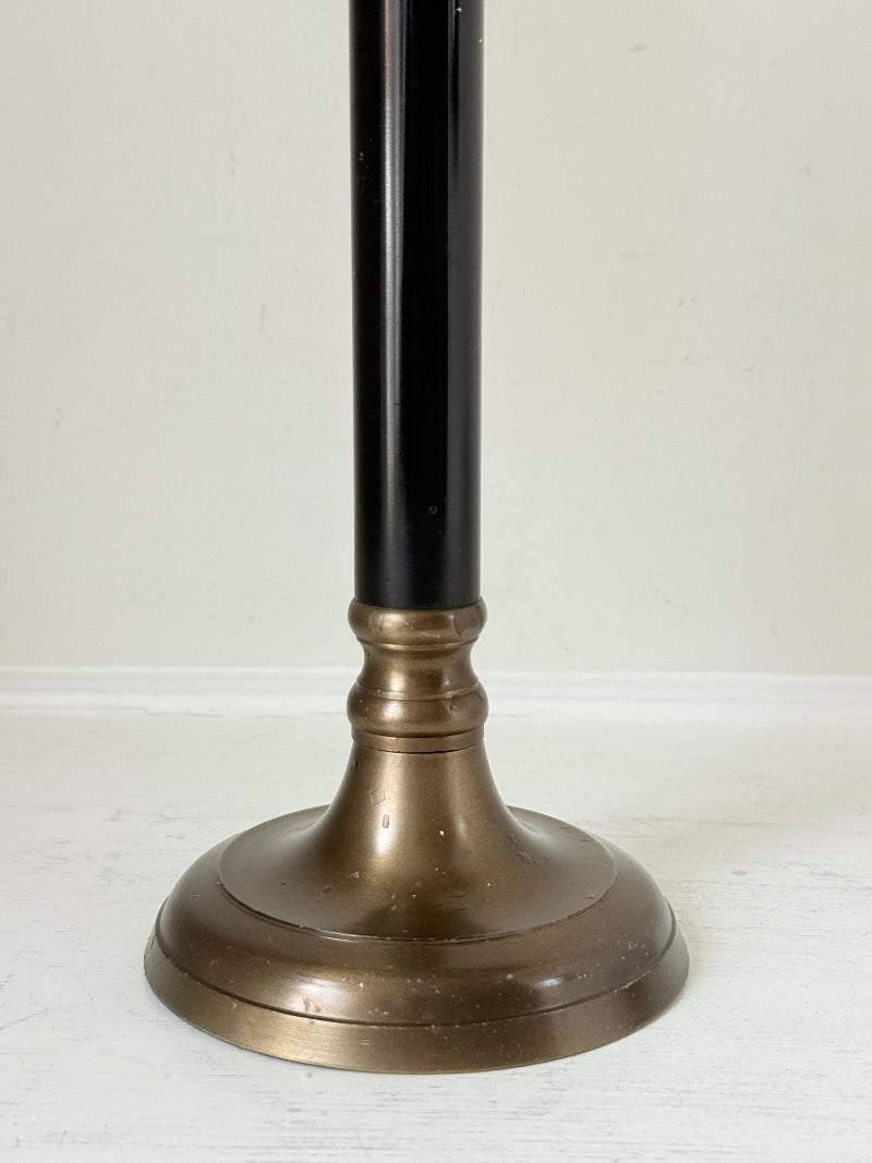 Vintage three arm candelabra in brass and ebonised metal with ivory taper candles styled on a white surface