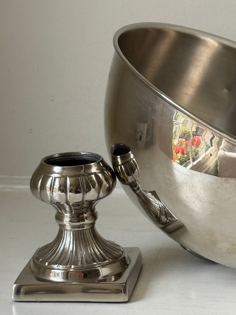 Vintage polished metal champagne bowl with pedestal base, photographed on a white surface