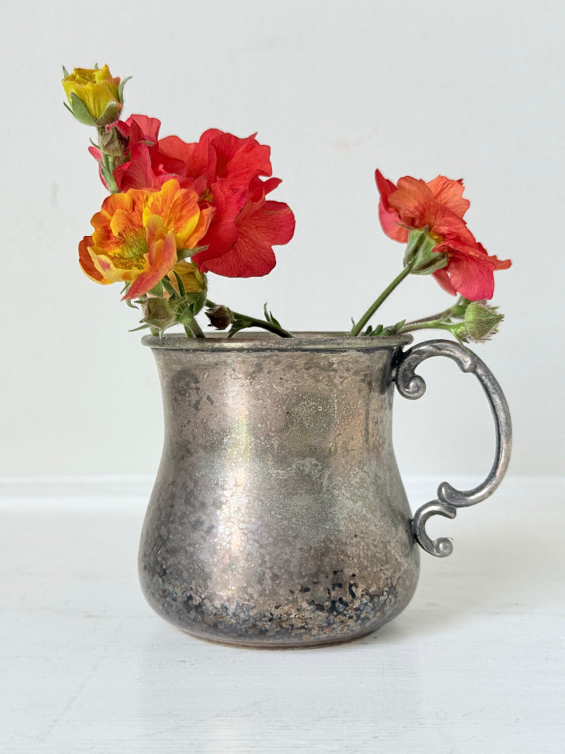 vintage silver plate beaker by arthur price with ornate handle and patina, photographed with red flowers on a white surface