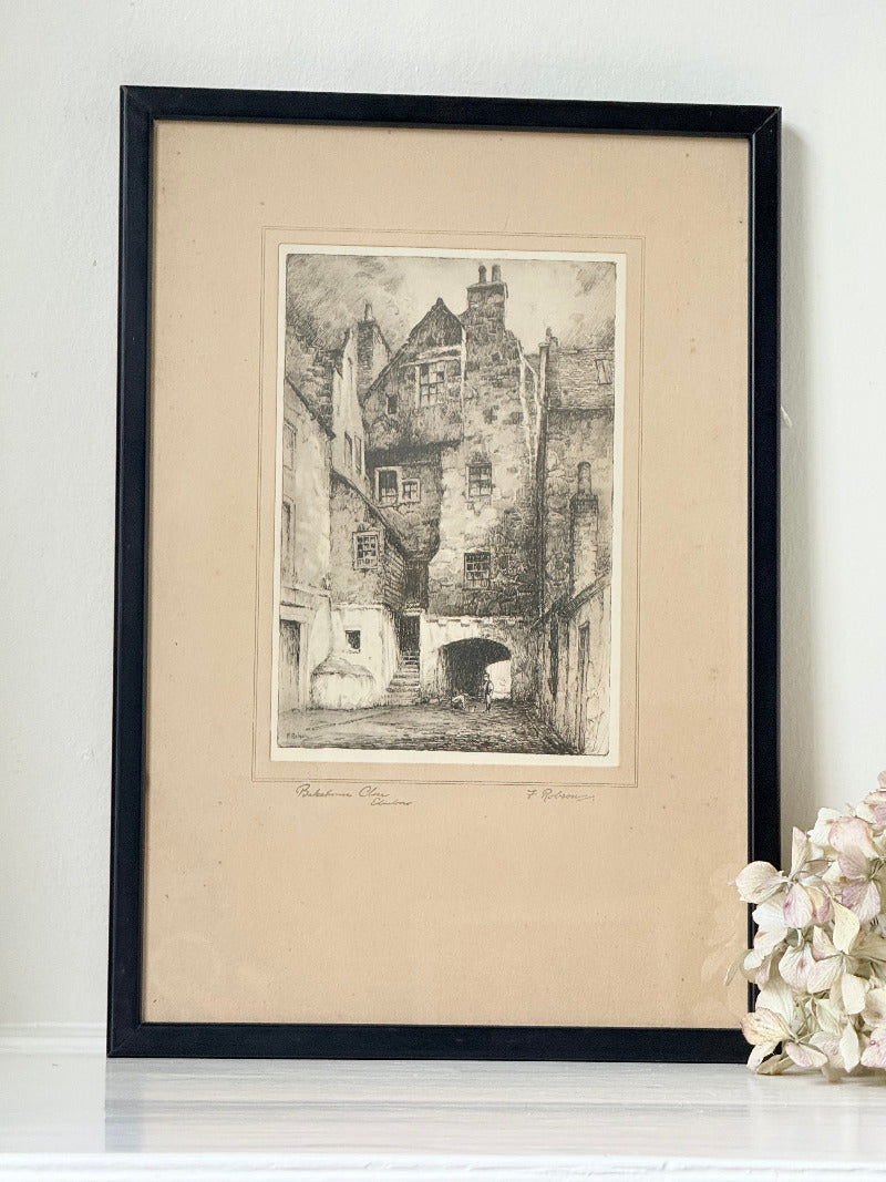 framed black and white print of edinburgh old town architecture photographed on white surface