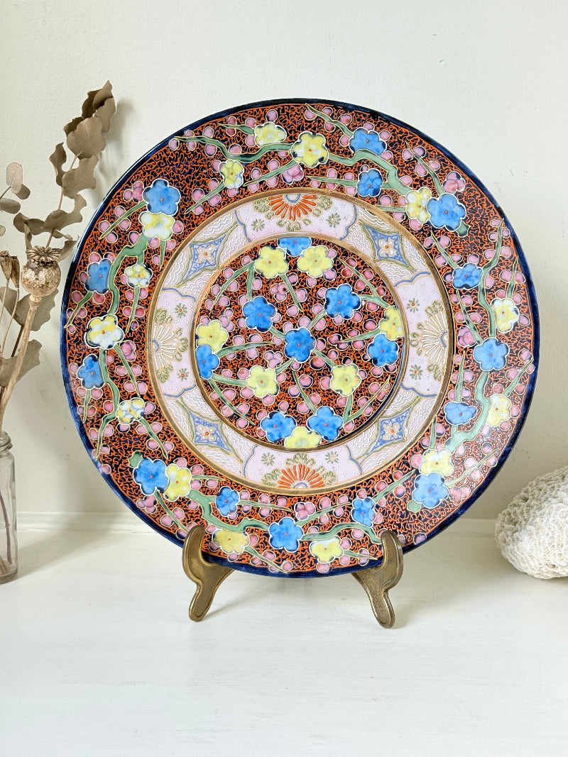 Antique Japanese Aoki Brothers platter with colourful Imari style floral pattern photographed on a white surface