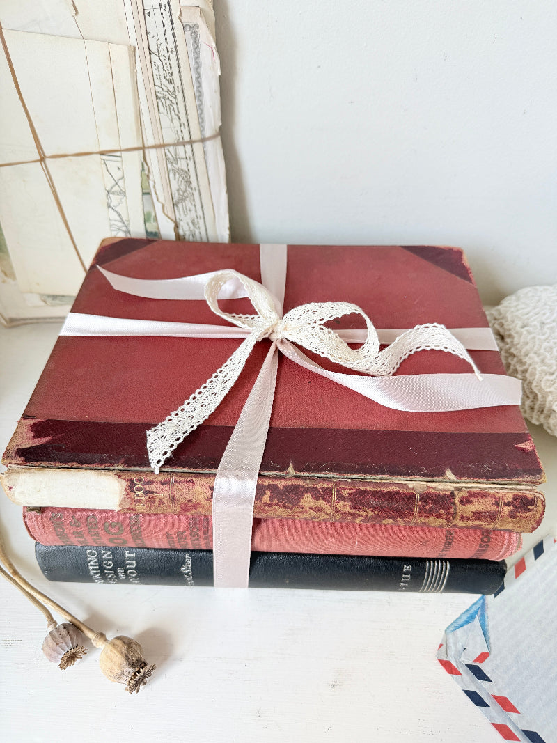 Large vintage decorative book bundle with burgundy cream and green hardback covers tied with ribbon for interior styling