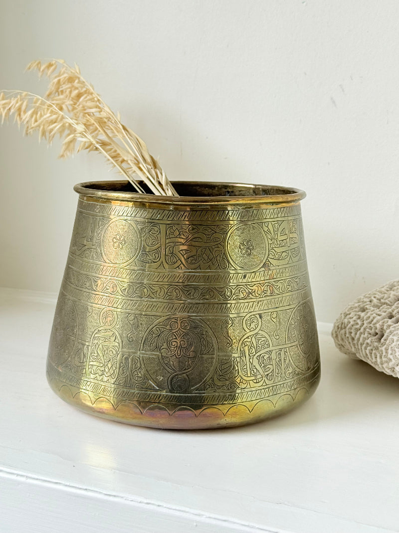 Large vintage brass pot with engraved decoration and aged patina, photographed on a white surface