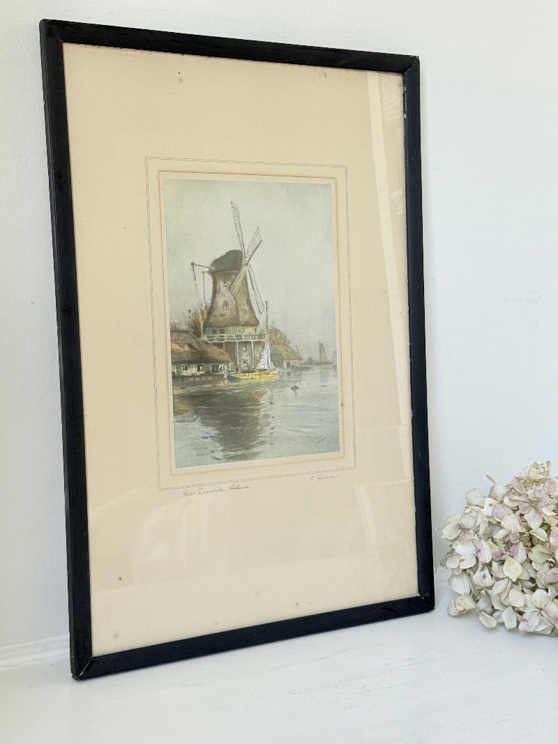 framed print of dutch windmill beside water in holland with reflection photographed on white surface