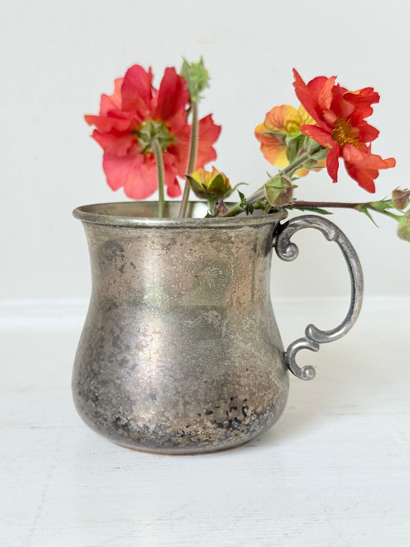 vintage silver plate beaker by arthur price with ornate handle and patina, photographed with red flowers on a white surface