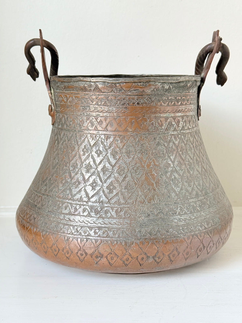 antique Middle Eastern water ewer with engraved diamond and foliate pattern and copper base, displayed on white surface