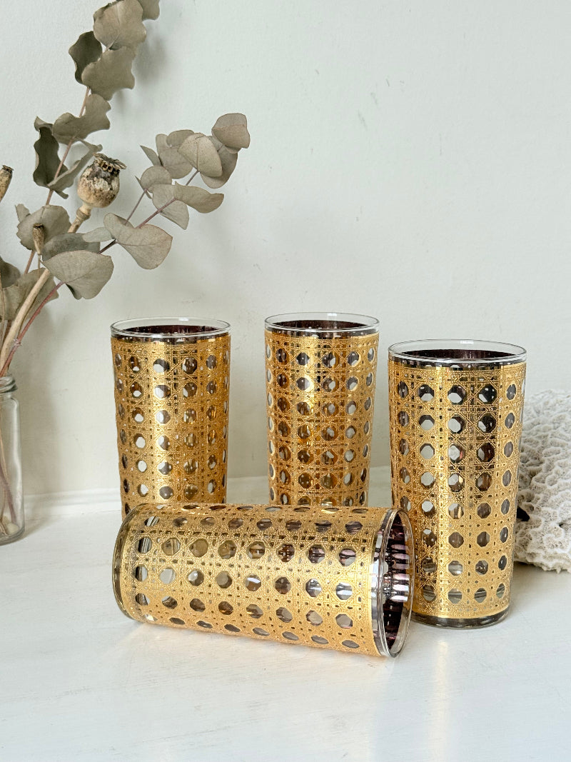 Set of 4 vintage gold rattan effect glasses with pierced lattice sleeves, photographed on a white surface