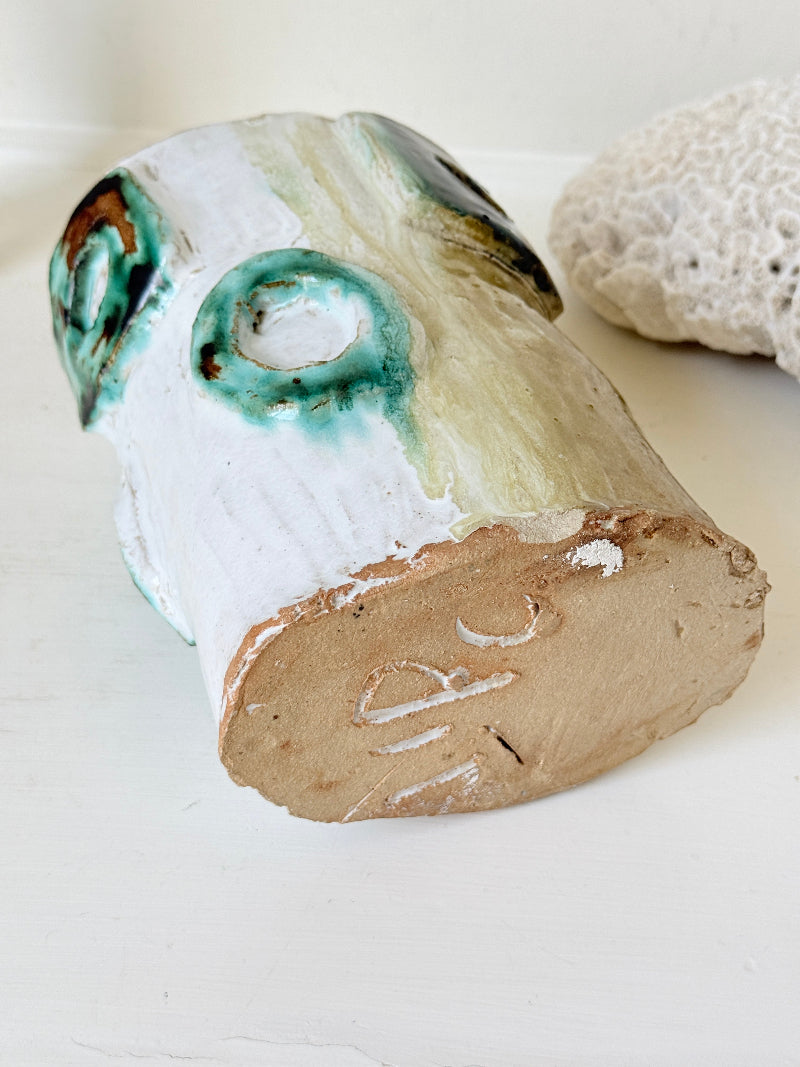 Vintage studio pottery vase in white, ochre and turquoise with abstract applied decoration, photographed on a white surface