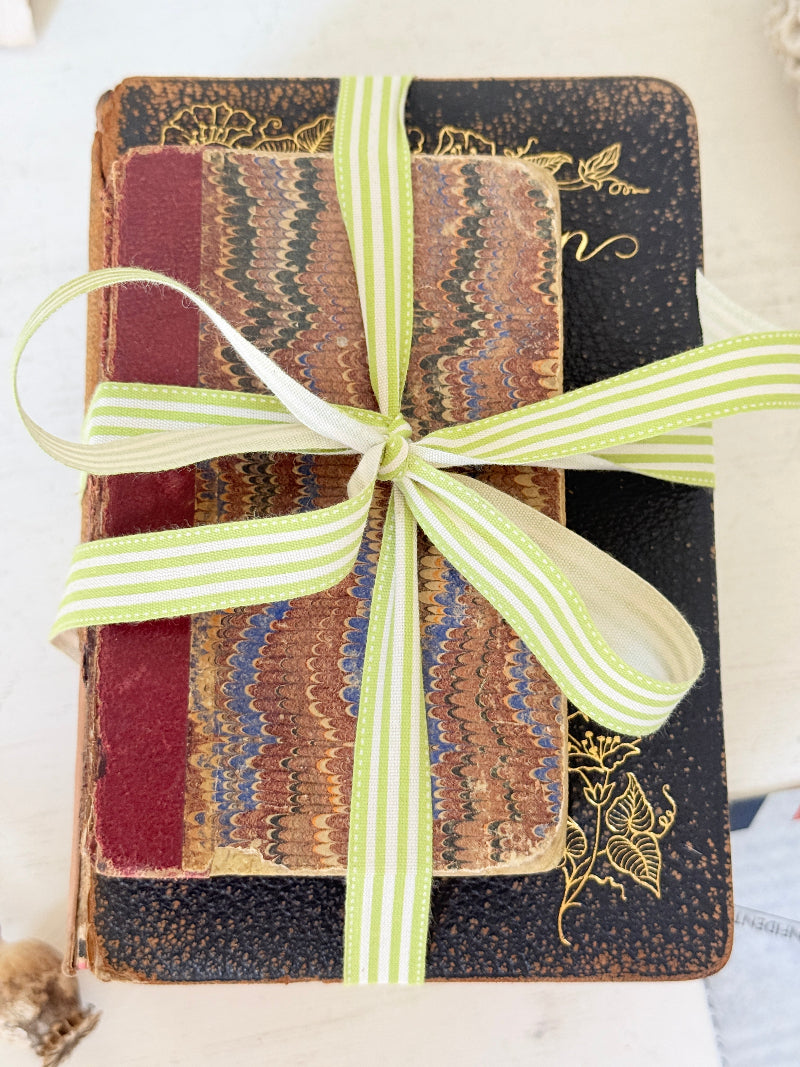 Vintage decorative book bundle with red burgundy cream and green hardback covers tied with green stripe ribbon for interior styling
