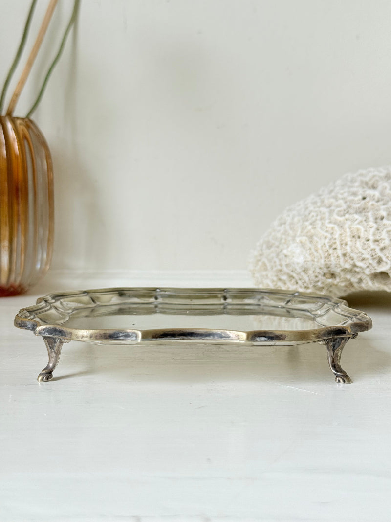 Vintage silver plate tray with scalloped edge and footed base, photographed on a white surface