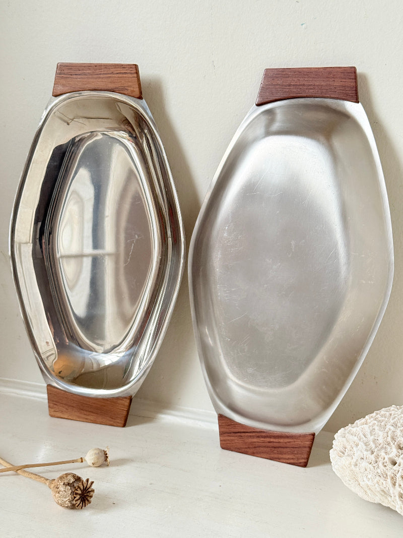 Pair of mid century stainless steel and teak crudites dishes photographed on a white surface