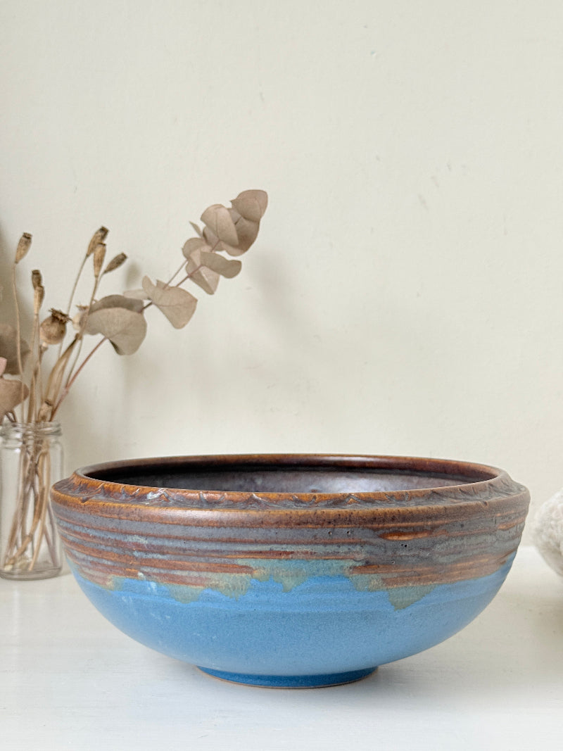 Vintage Bourne Denby stoneware fruit bowl in blue and brown glaze, photographed on a white surface
