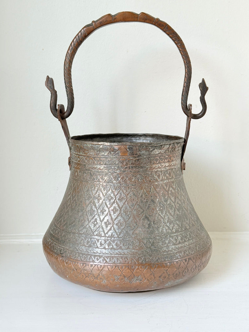 antique Middle Eastern water ewer with engraved diamond and foliate pattern and copper base, displayed on white surface