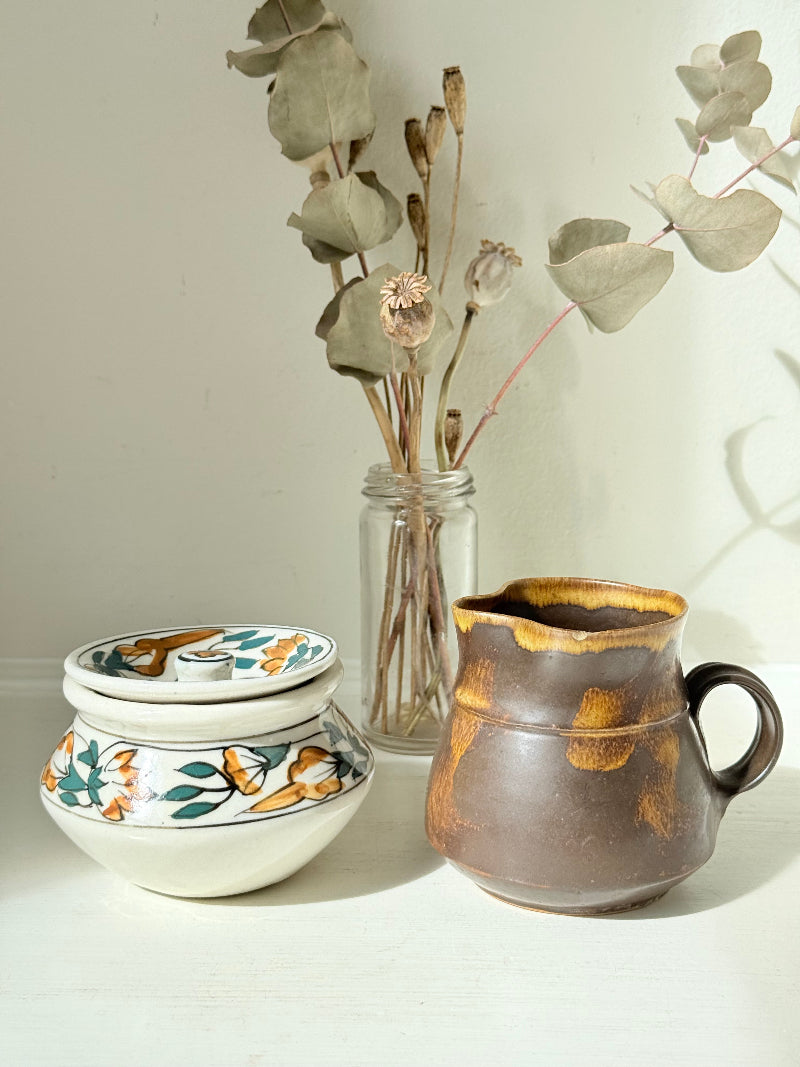 Studio pottery creamer and hand painted sugar bowl set, photographed on a white surface