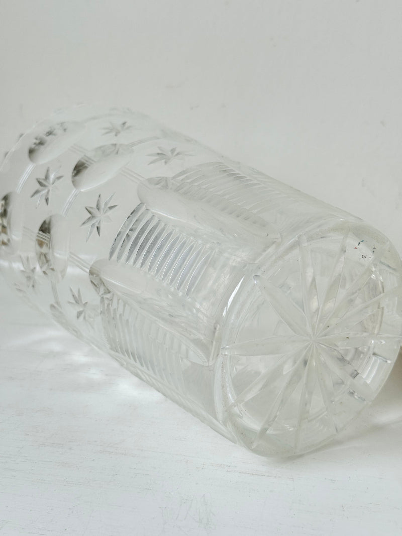 Vintage Stuart crystal cut glass vase with floral and star design, photographed on a white surface.
