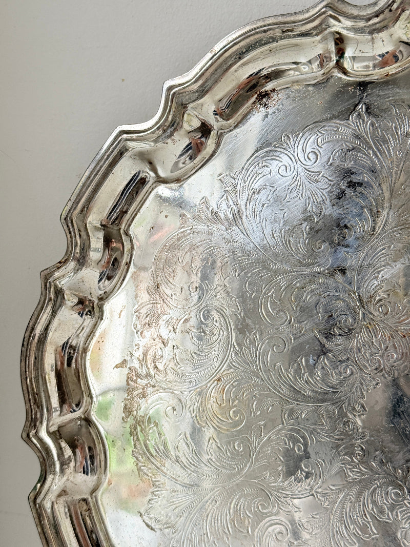 Vintage silver toned round serving tray with piecrust edge, aged patina and decorative scalloped rim for interior styling