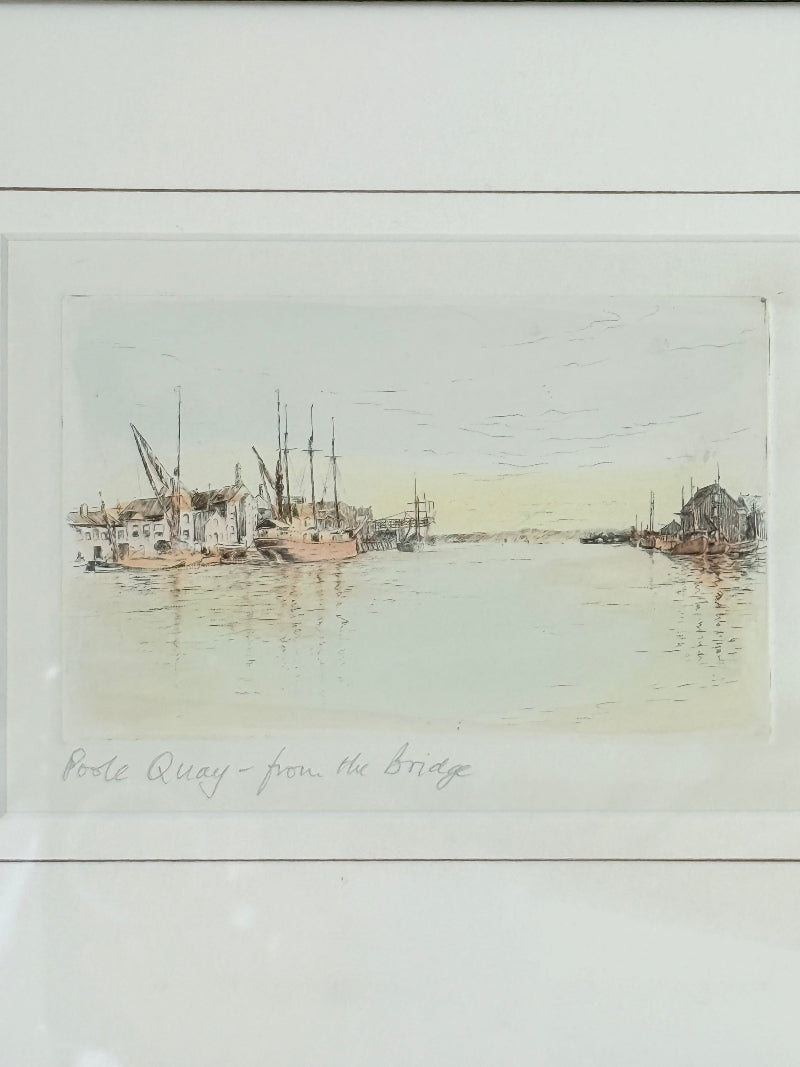 Framed vintage print of Poole Quay harbour scene in muted tones, under glass with gilt and wood-effect frame, on white surface.
