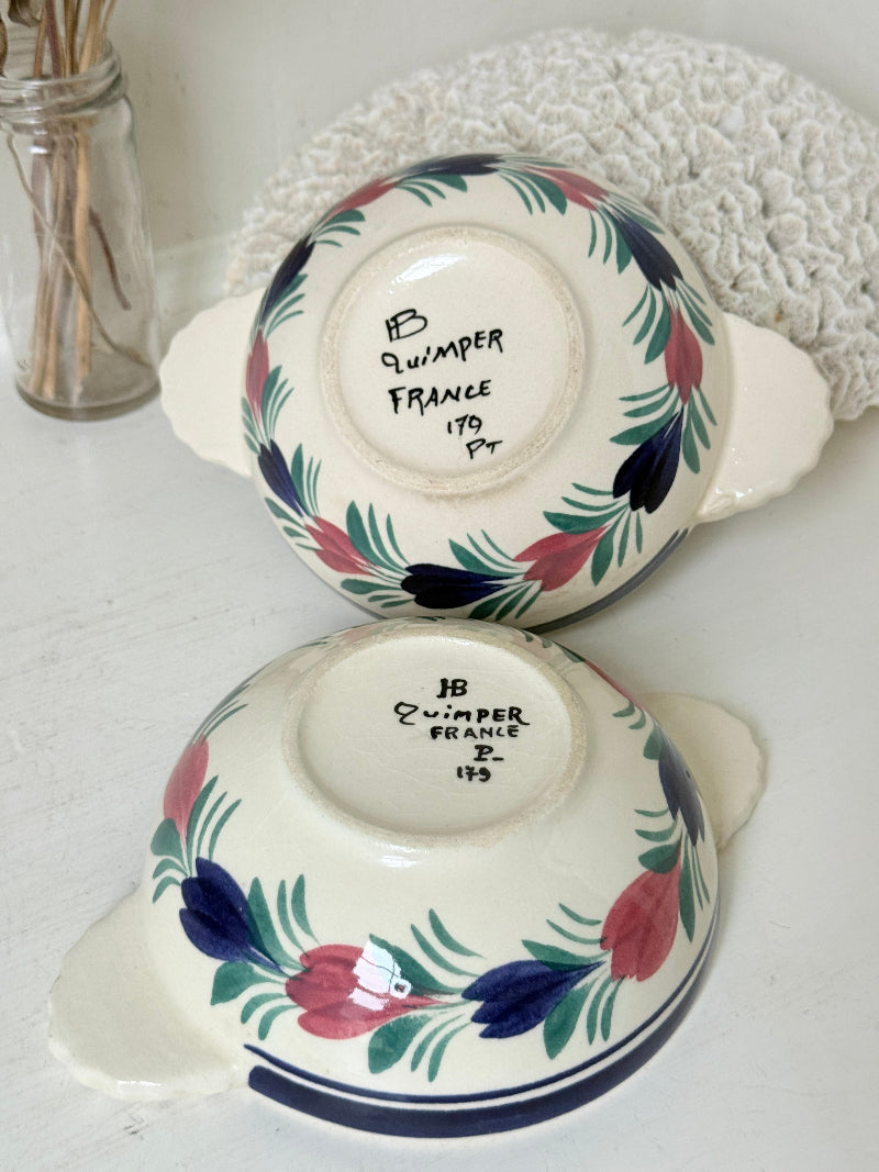 Pair of vintage French Quimper Breton figure snack bowls with painted side handles, photographed on a white surface
