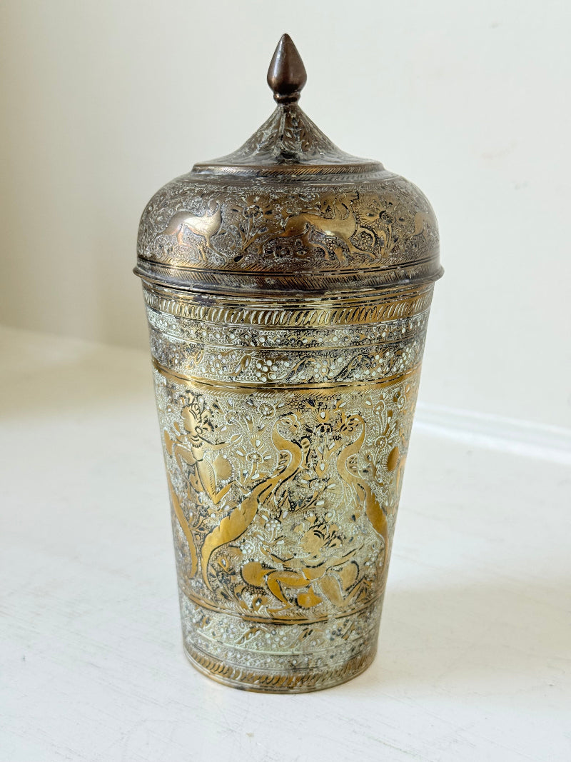 Indian Benares brass jar with lid and engraved animals and floral design, photographed on a white surface