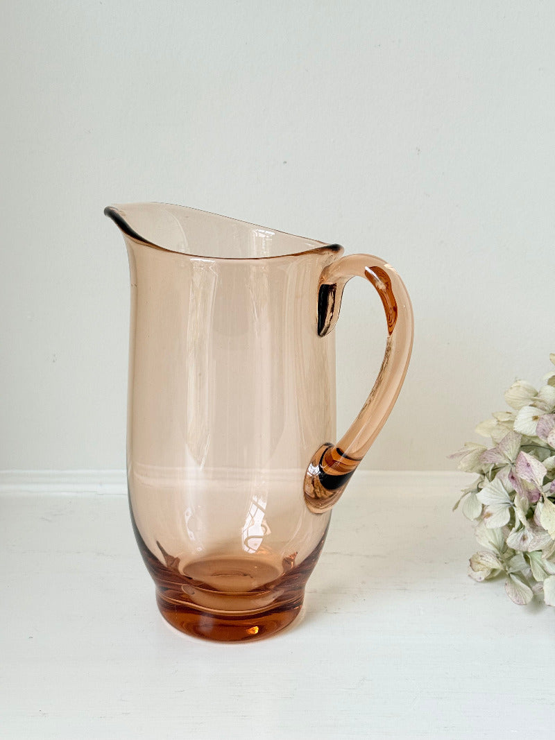 retro apricot glass serving jug with curved handle and flared spout, photographed on white surface