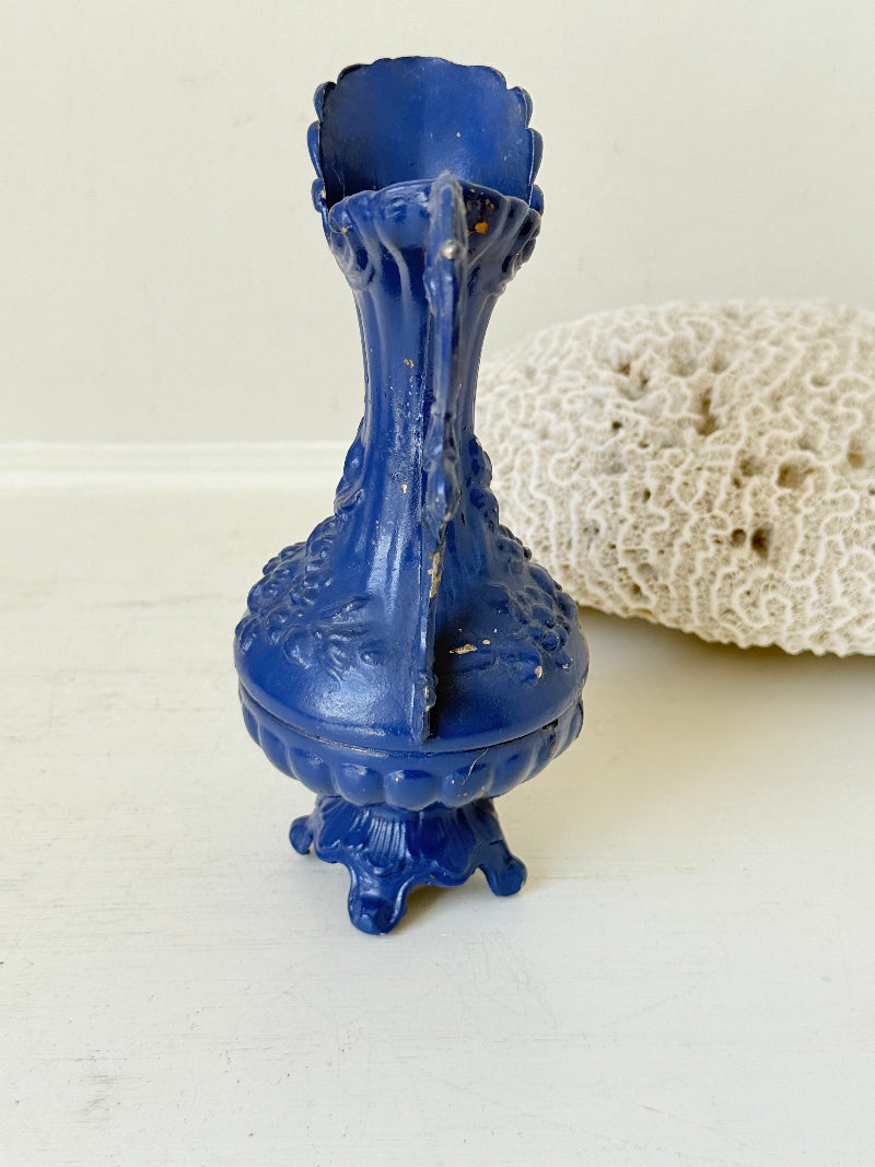 Blue vintage metal jug with ornate Rococo handle and relief decoration, shown on white background