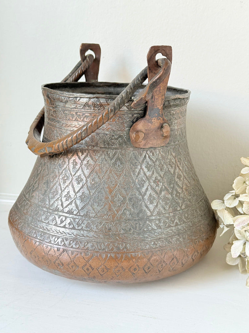antique Middle Eastern water ewer with engraved diamond and foliate pattern and copper base, displayed on white surface