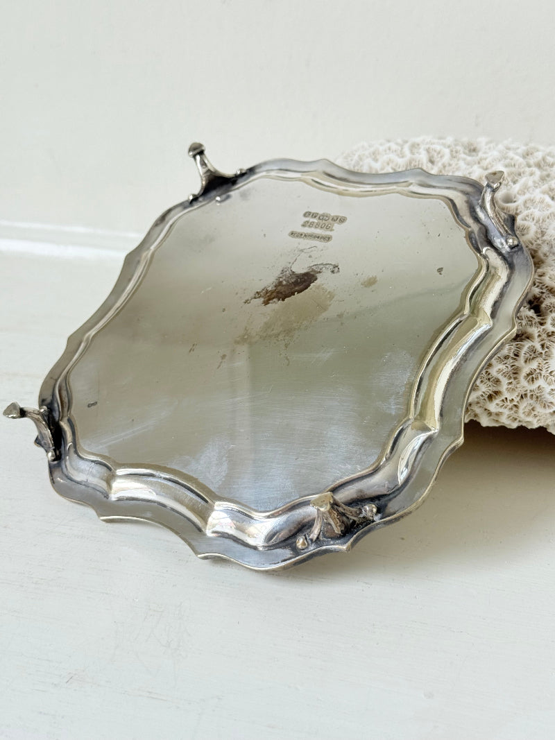 Vintage silver plate tray with scalloped edge and footed base, photographed on a white surface