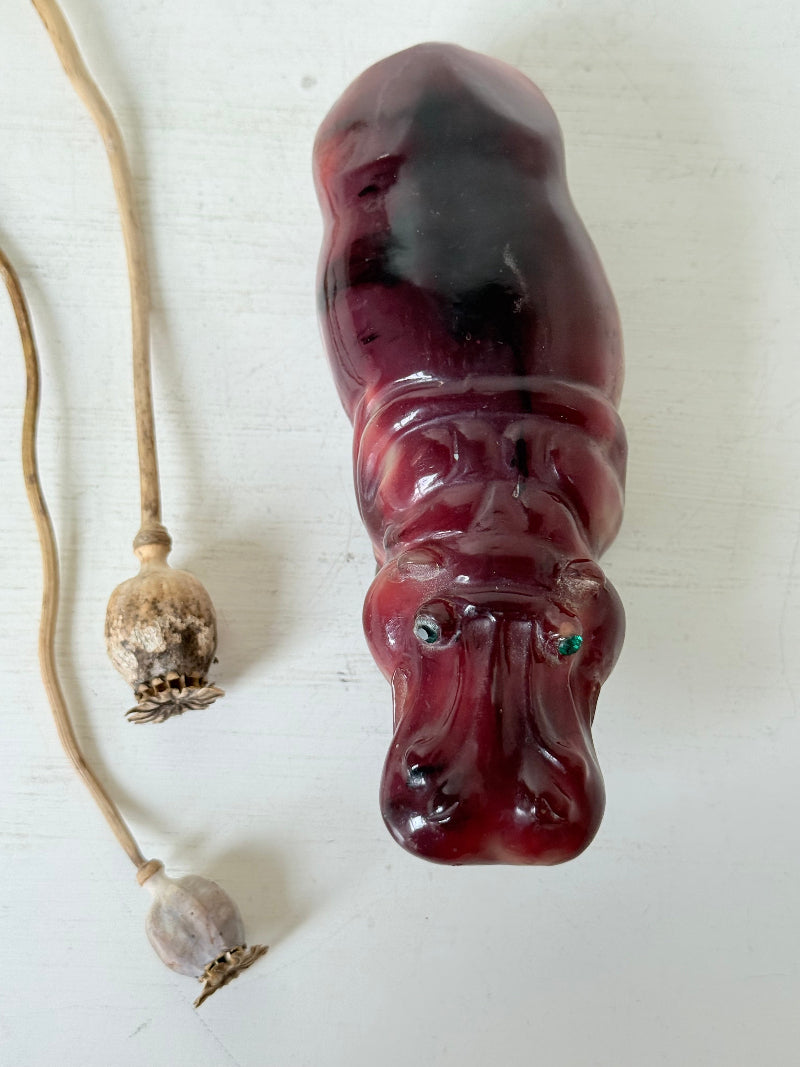Red polished stone hippopotamus ornament displayed on a white background.