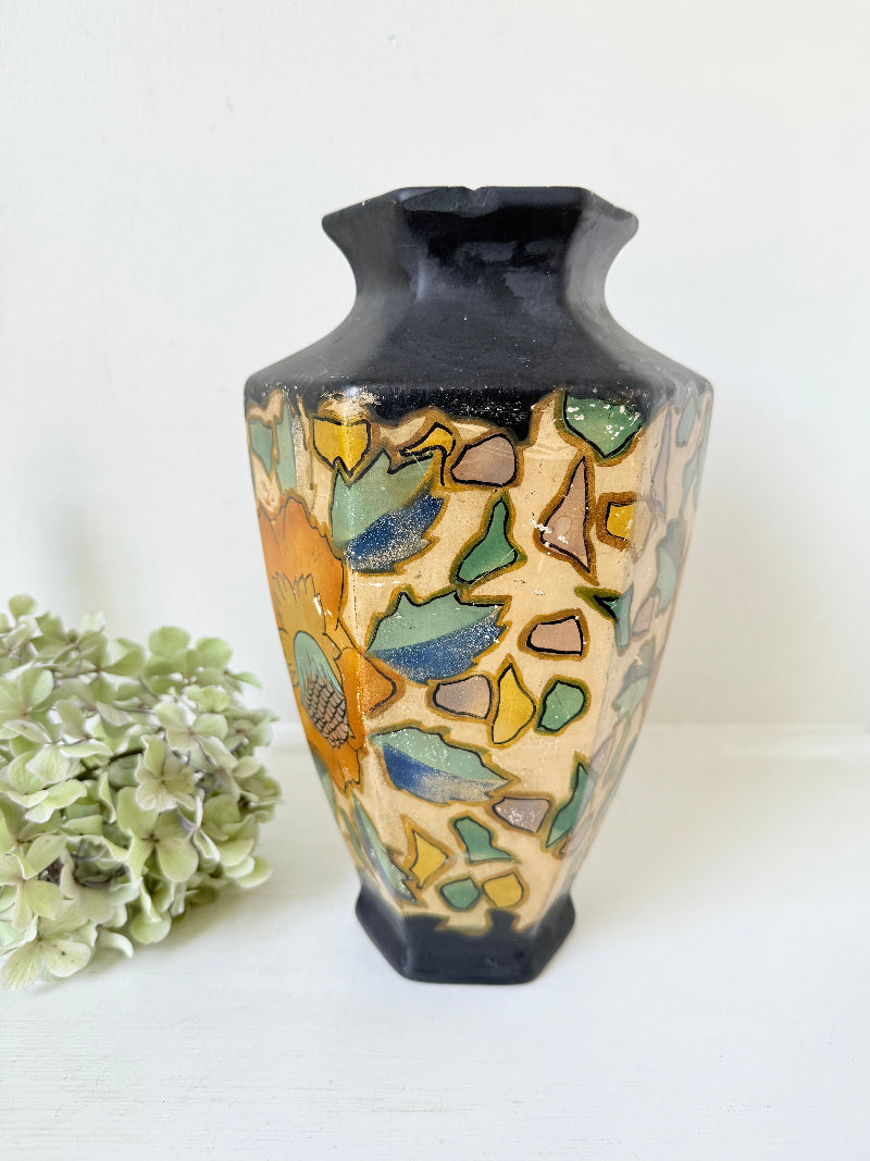 Art Deco Brentleigh Ware vase with hand painted floral design in orange, yellow, and teal on a black ground, photographed on a white surface