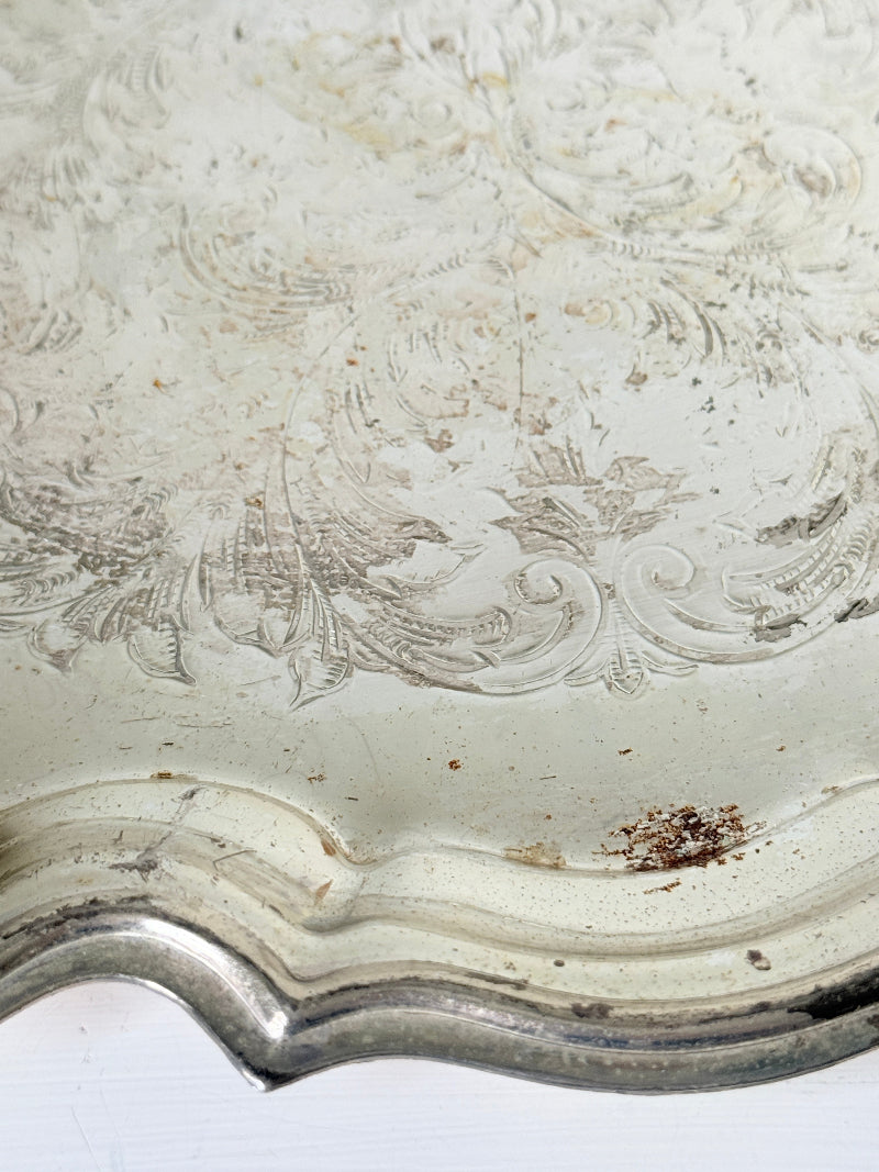 Vintage silver toned round serving tray with piecrust edge, aged patina and decorative scalloped rim for interior styling