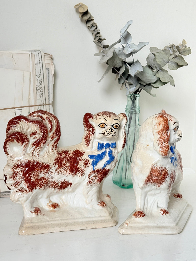 Pair of antique standing Staffordshire Pekingese dogs in rust red and white with blue painted bows