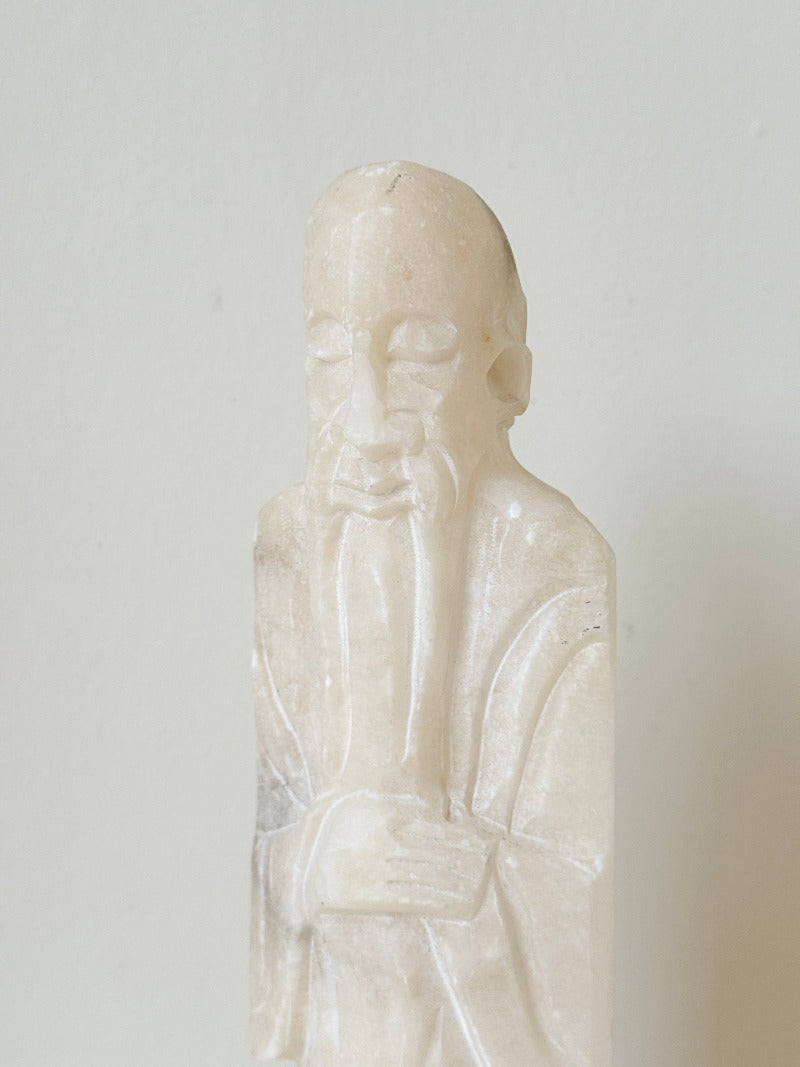 vintage alabaster gentleman figure on square base with carved detail, photographed on white surface with hydrangea flowers.