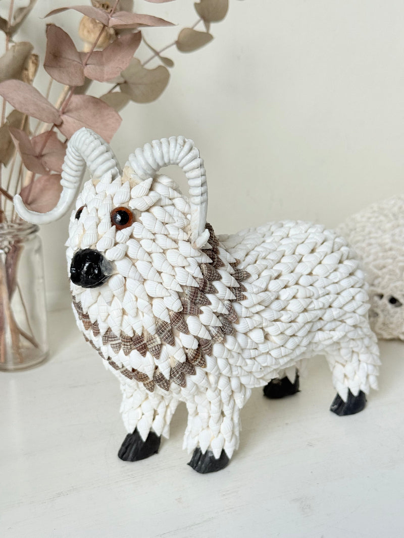 Vintage shell ram ornament in cream and brown, photographed on a white surface