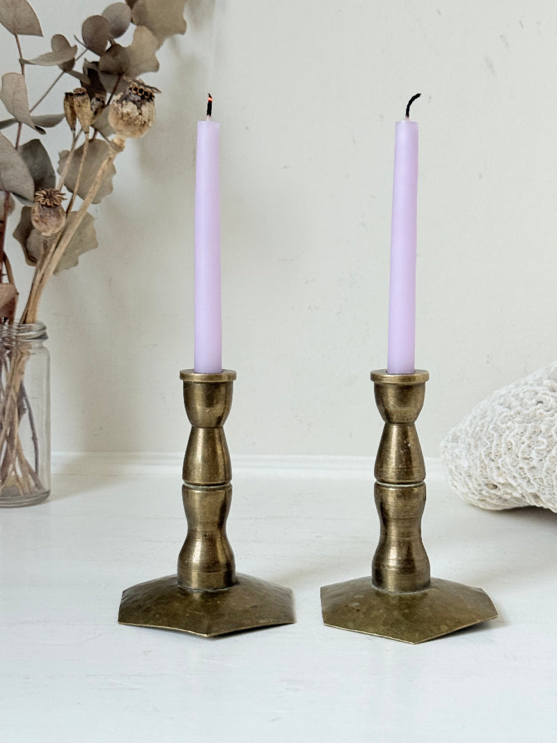 Pair of miniature brass candlesticks with hex bases photographed on a white surface