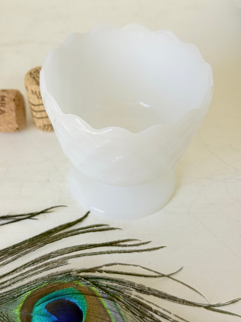 Vintage milk glass footed bowl with scalloped rim and pressed pattern, photographed on a white surface