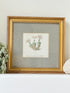 vintage botanical print of primula Tirolensis in gold frame on white surface with green hydrangeas