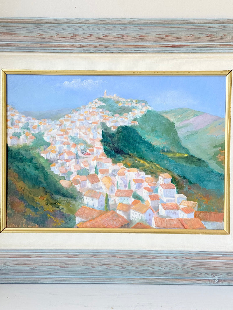 Framed oil painting of Costa del Sol with whitewashed hillside towns, photographed on a white surface