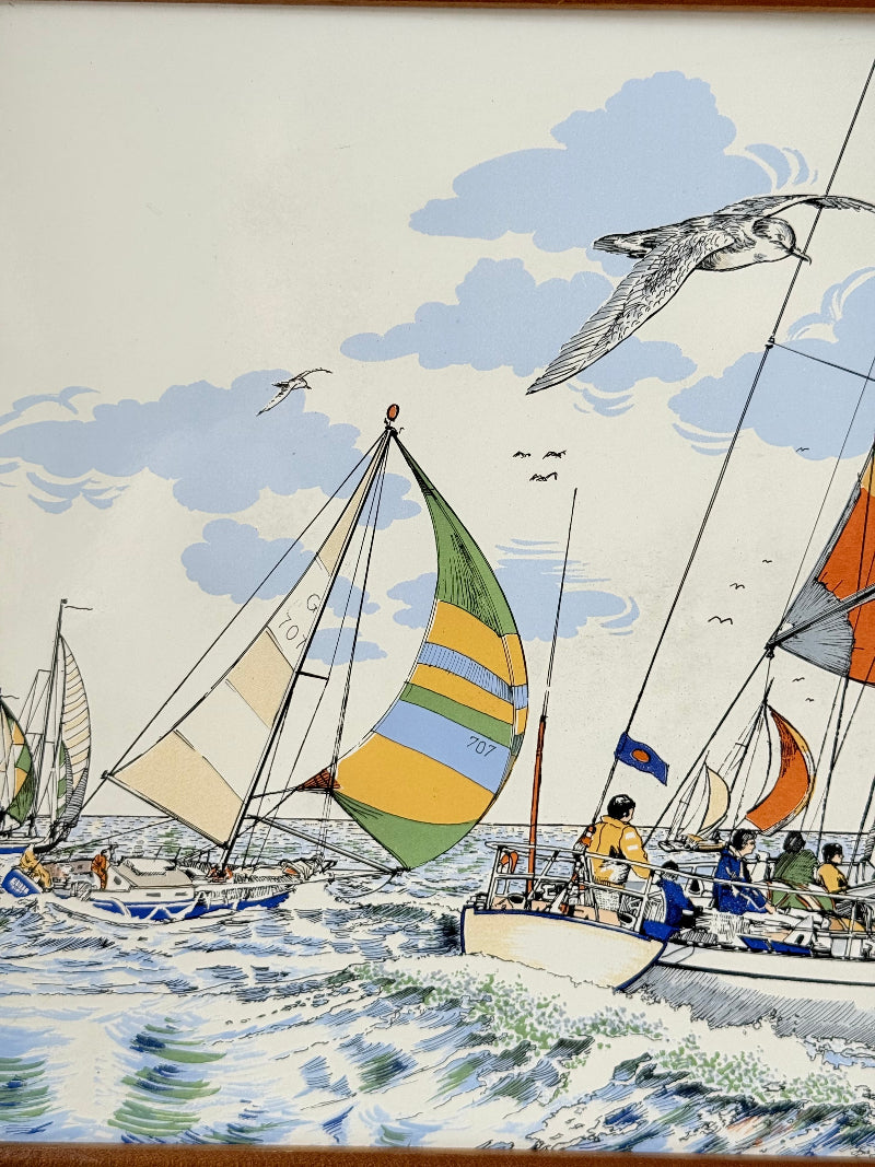 Vintage enamel artwork of sailing yachts with colourful striped sails in a regatta, framed in wood, photographed on white surface.