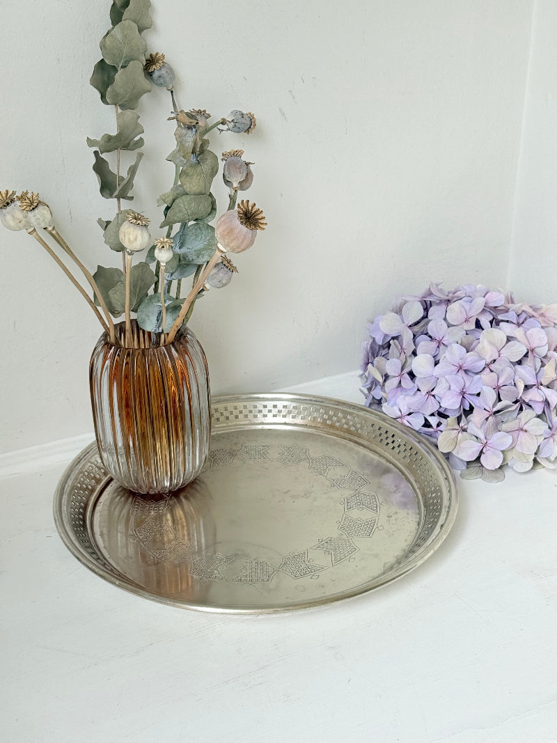 Vintage round silver plate tray with brass rim, pierced edge and etched central motif, photographed on white surface